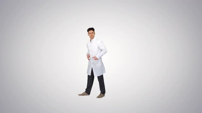 年轻的医生穿着实验室外套做正面翻转胜利!在渐变背景上