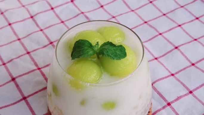 自制哈密瓜和西米奶。泰国甜点瓜球和薄荷在顶部。泰国菜。