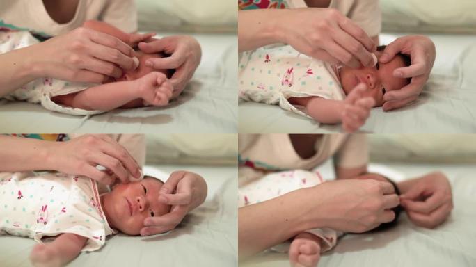 母亲洗完澡后清洁眼睛的婴儿