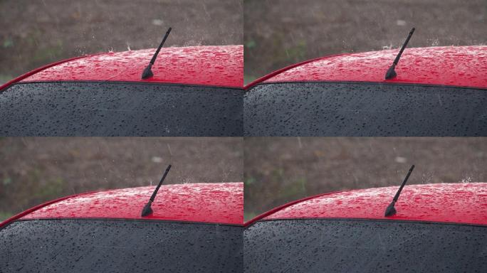 雨落在车顶的红色汽车上。