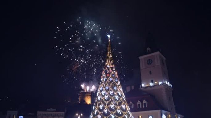 罗马尼亚布拉索夫镇广场圣诞树上的烟花闪闪发光