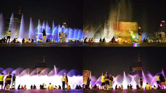许多人晚上看五颜六色的喷泉
