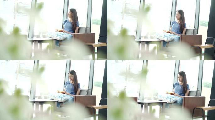 一位年轻女士正坐在窗台上看书