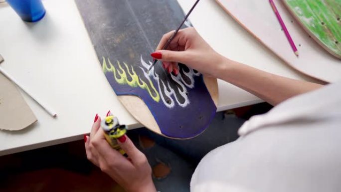 妇女在滑板板上绘画的特写镜头