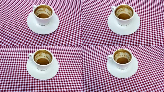一杯红床单的卡布奇诺咖啡放在桌子上。咖啡时间到了。