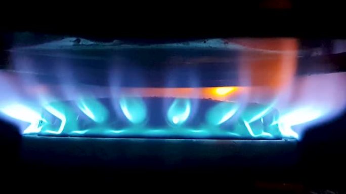 来自隔离炉灶的充满活力的蓝色火焰，从侧面看非常近，聚焦在屏幕中央
