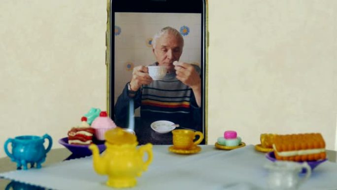 老人使用视频通话在娃娃桌上喝茶