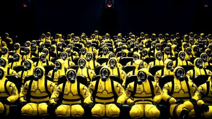 穿着细菌防护服的人坐在电影院里等着电影。穿着黄色防护服和防毒面具的人。