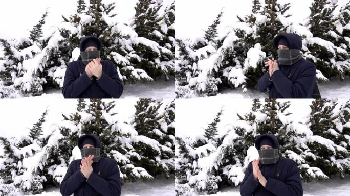 一个穿着围巾的白人年轻人在冬天冻结在大自然上。雪中云杉的树木，慢动作