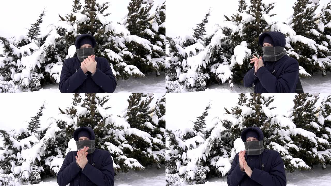 一个穿着围巾的白人年轻人在冬天冻结在大自然上。雪中云杉的树木，慢动作