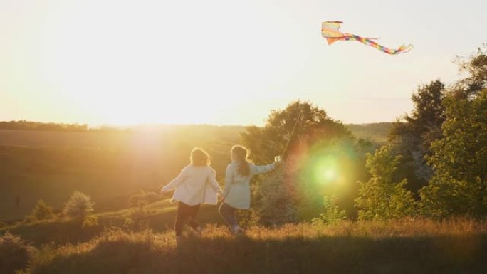 妈妈和女儿在日落时玩风筝