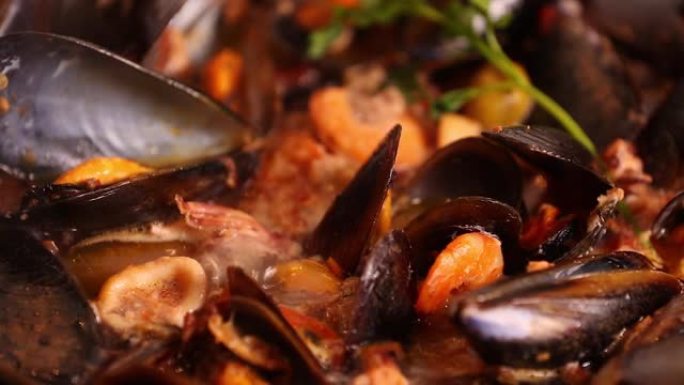 在火炉上烹饪传统的意大利地中海鱼汤，杂烩，虾，贻贝番茄，鱿鱼，蛤。海鲜。关闭