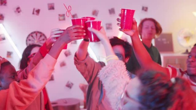 年轻的朋友在敬酒中点击杯子，在家庭聚会上跳舞