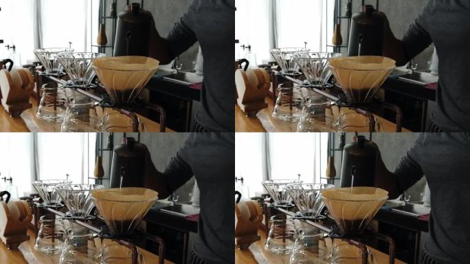 咖啡师手工煮咖啡。加入研磨咖啡并倒入热水。将热水洒在咖啡粉上，手滴咖啡。内部射击。咖啡馆氛围。咖啡馆