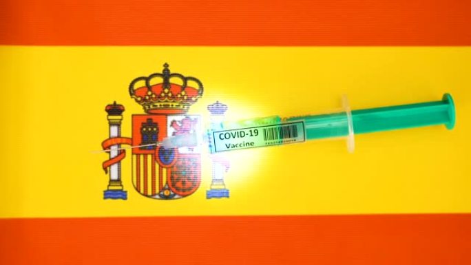 实验室医生将用于冠状病毒或新型冠状病毒肺炎疫苗的小注射器放在西班牙国旗上