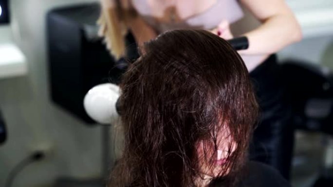 特写，理发师用吹风机干湿头发，慢动作
