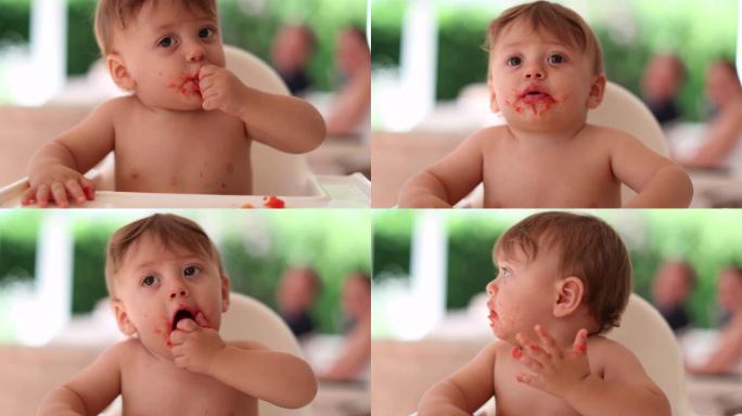 可爱的乱七八糟的宝宝自己吃，光着膀子的蹒跚学步的宝宝吃食物
