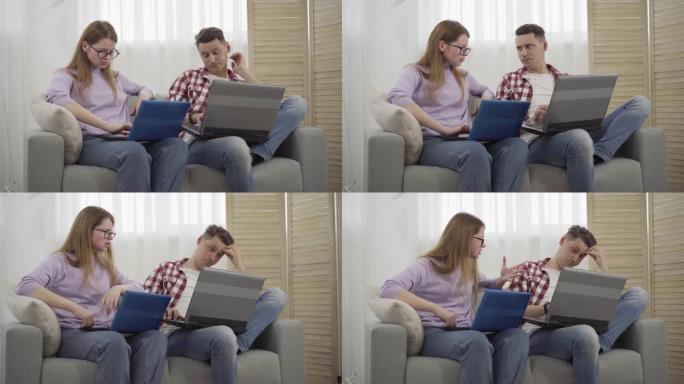紧张的红发女人对褐发年轻男子大喊大叫，向她展示他的笔记本电脑屏幕。肖像不满的白人女友与男友争吵在家里