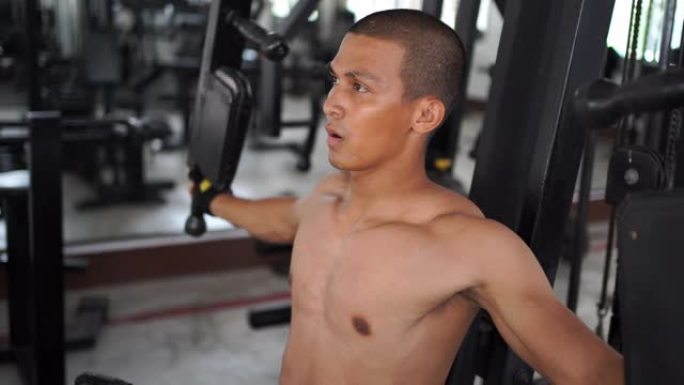 亚洲男模正在健身房锻炼。