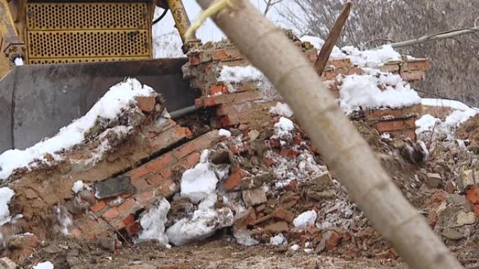 工业挖掘机和推土机将碎屑和拆除混凝土墙装入集装箱。强大的推土机移动和铺土。这条路正在建设中。