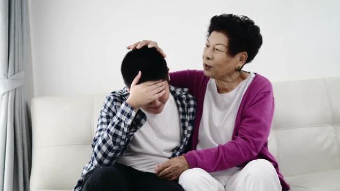 亚洲高级女性试图让孙子在家中的不良情绪平静下来。