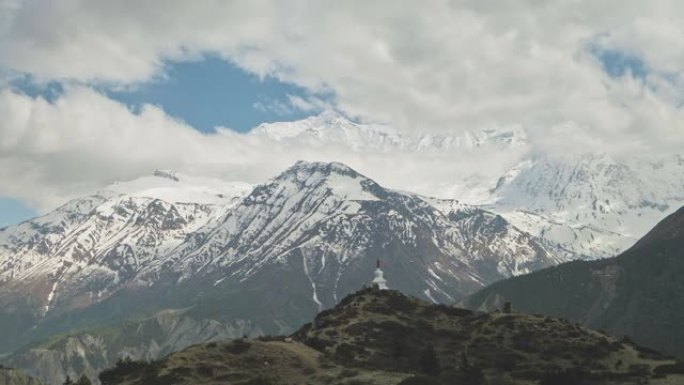 全景，山顶上的佛塔，云层中的白色冰川山地块旁边