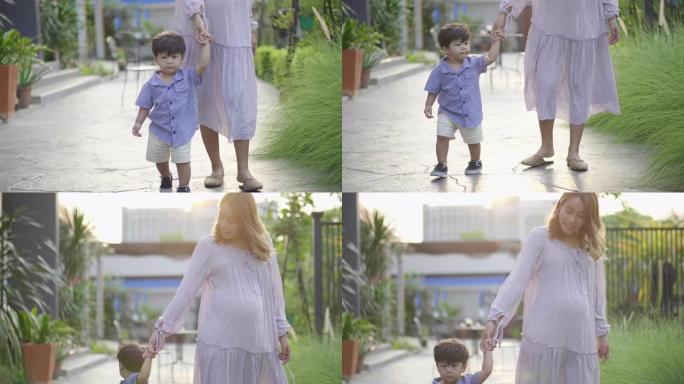 男婴握着母亲的手走在街上
