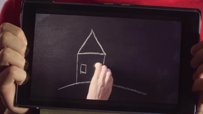 特写男孩拿着平板电脑，女人的手绘房子有树