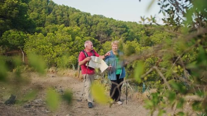 活跃的西班牙老年人在白天远足时咨询地图