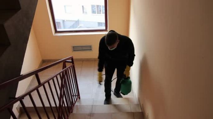 男子在新型冠状病毒肺炎大流行期间对住宅楼梯和栏杆进行消毒