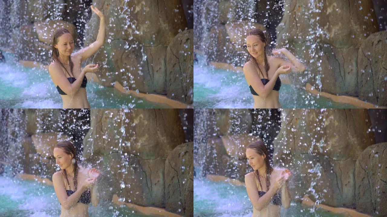 一个热带度假胜地的年轻女子，有温泉，瀑布和游泳池，里面有热矿泉水。慢动作镜头