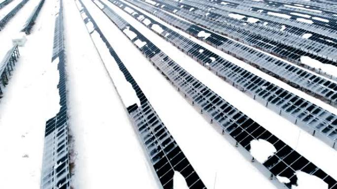 空中: 冬天被雪覆盖的光伏。雪中的太阳能电池板被雪覆盖。北欧国家的替代能源。
