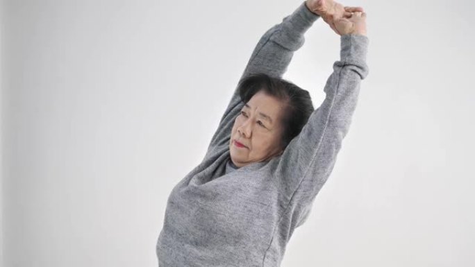 亚洲老年妇女在家里锻炼和跳舞，呆在家里的生活方式概念。