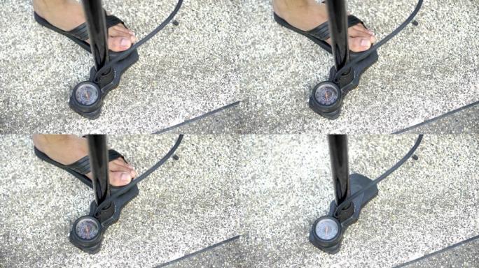 亚洲男子在家里给自行车车轮充气并向轮胎漏气