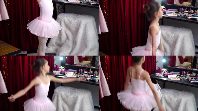 4k快乐美丽的小芭蕾舞女舞者穿着粉色芭蕾舞裙在更衣室的镜子前练习舞蹈。微笑可爱的女孩享受在化妆室跳舞