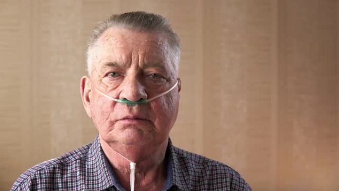 一位老人用医用鼻氧导管深呼吸的肖像