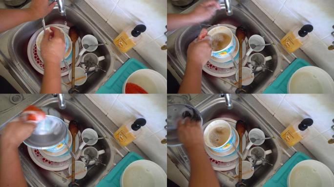 男人手工做家事洗碗在水槽里用手冲洗盘子