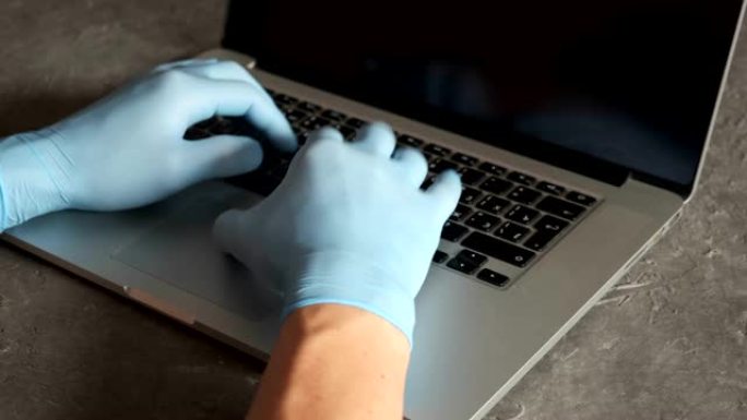 年轻的印度商人戴着医用口罩手套，坐在家庭办公室的笔记本电脑上工作。在冠状病毒covid 19检疫概念