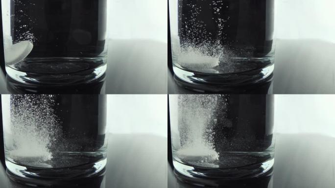 药丸掉在杯子里的特写镜头。