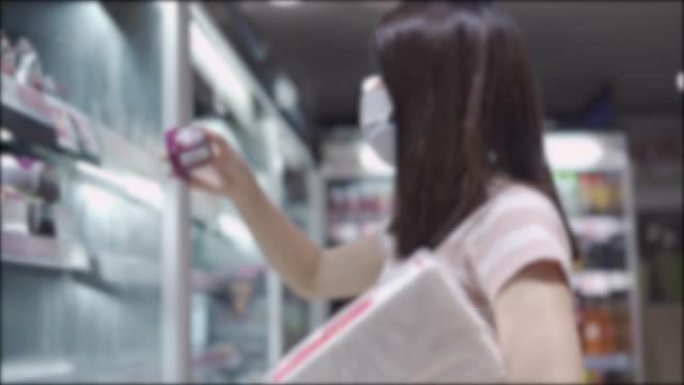 BLUR拍摄亚洲妇女在杂货店购买医用口罩，储备食品和健康用品，covid19日冕病毒大流行危机期间的