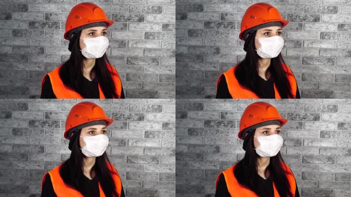 灰色砖墙背景下脸上戴着医用面具的年轻女子肖像。成年女性用口罩遮住脸，以保护自己免受疾病的侵害。冠状病