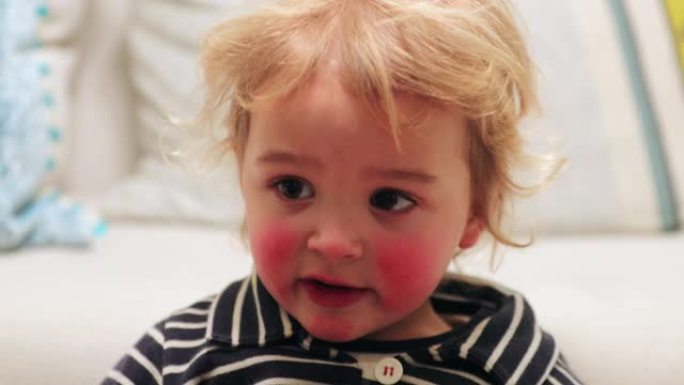 镜头外主演的金发儿童婴儿婴儿幼儿特写镜头，红色cheaks