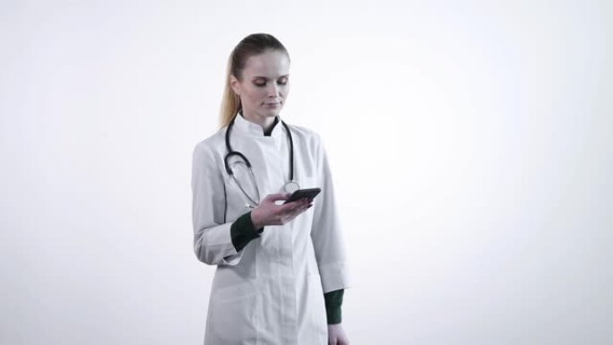 一位女医生看着智能手机。医生在看新闻提要。