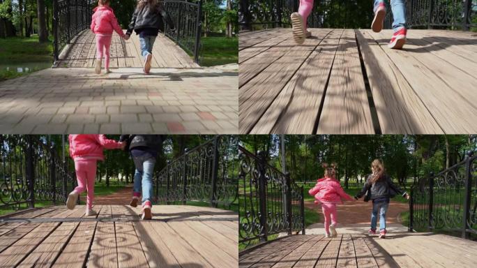 欢快的孩子们牵着手在桥上的公园里奔跑。慢动作镜头
