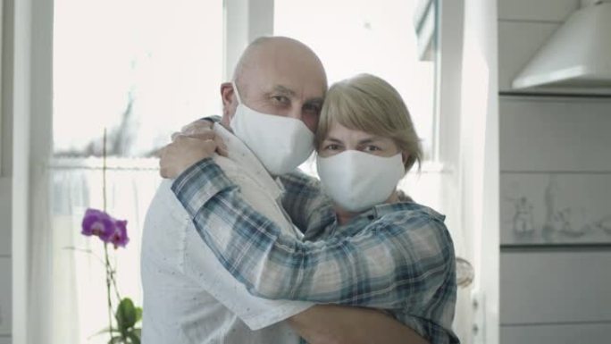 瓜兰汀医用口罩成熟夫妇的肖像。他们拥抱。