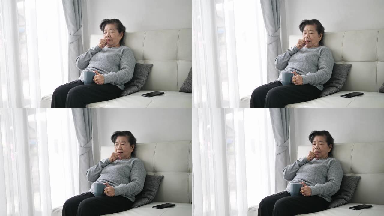 亚洲老年妇女在家头痛和咳嗽，保健理念。