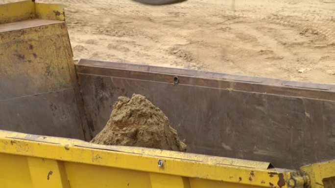 推土机挖掘机在街道重建现场装载到自卸车。工业卡车装载机挖掘机运土卸载成自卸车
