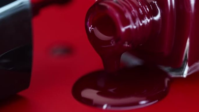 一瓶指甲油躺在红色背景上。