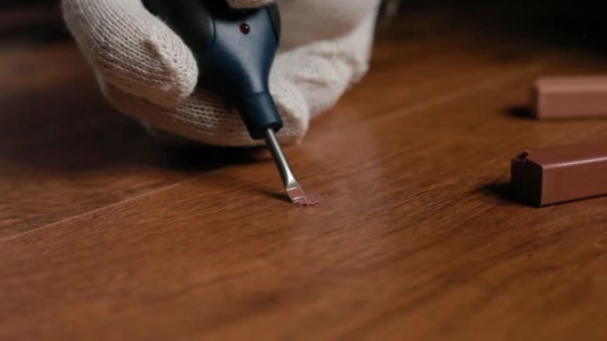 用蜡和烙铁修复木地板层压板的镶木地板。