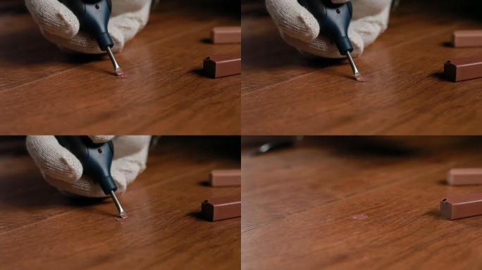 用蜡和烙铁修复木地板层压板的镶木地板。